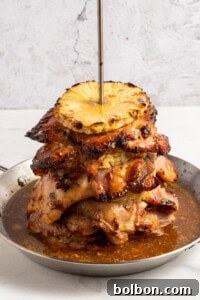 Aloha Chicken Gyro 9 A stack of golden-brown grilled chicken and pineapple rings, still on the vertical spit, removed from the oven and sitting on a baking sheet, glowing from the heat.