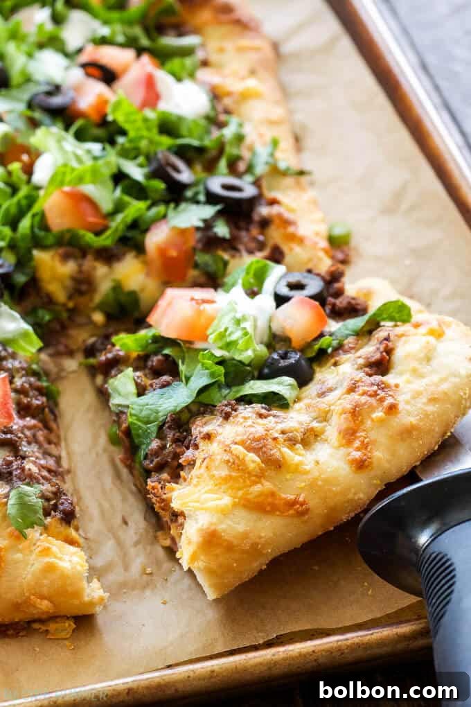 25 Fast and Easy Ground Beef Dinners 6 A top-down view of vibrant Taco Pizza, loaded with seasoned ground beef, melted cheese, and fresh toppings like lettuce and tomatoes, highlighting creative ground beef recipes.