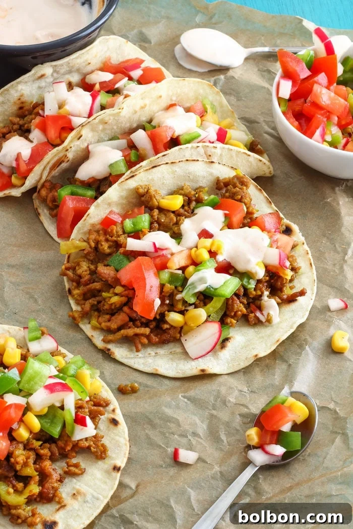 25 Fast and Easy Ground Beef Dinners 7 A close-up shot of Curry Beef Tacos with Sweet Corn Salsa, showcasing the colorful and flavorful filling in soft tortillas, representing unique ground beef dinner ideas.