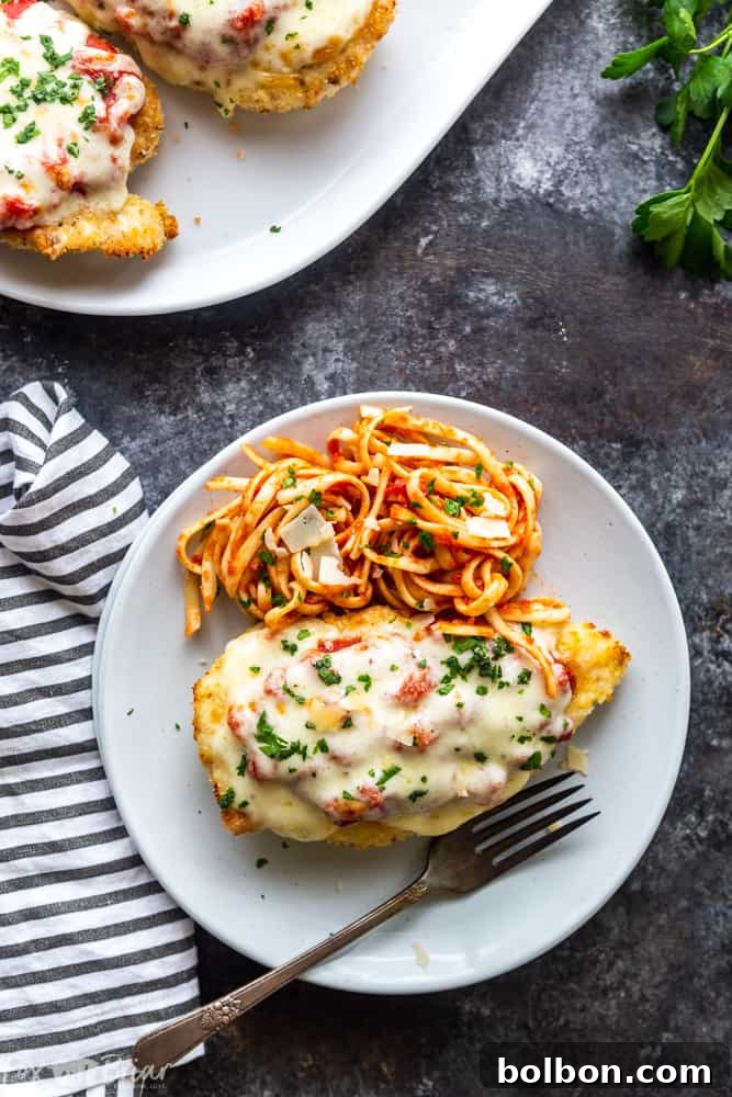 Garnished Oven Baked Chicken Parmesan, showcasing its readiness to be served. A quick, easy, and healthy chicken recipe for dinner, perfect for Italian food lovers looking for a less greasy option.