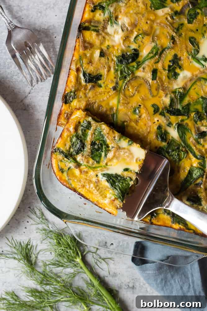 Delicious Make Ahead Breakfast Casserole with Sausage and Veggies, perfect for an easy, gluten-free, and keto-friendly meal prep breakfast. Features a golden-brown top with visible sausage, spinach, and eggs, served hot from a baking dish.