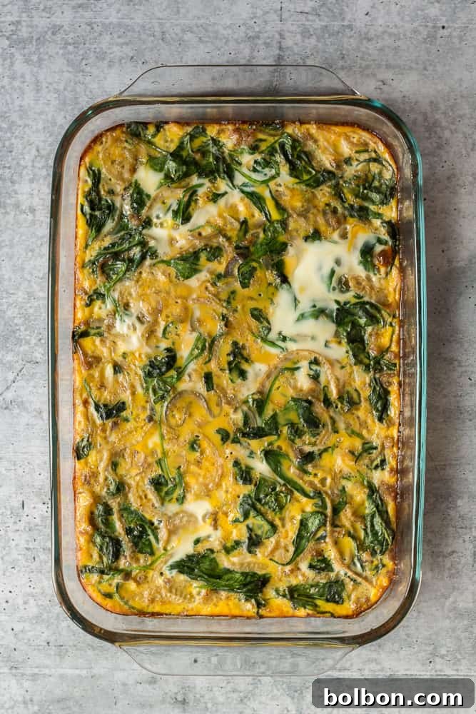 Baked Make Ahead Breakfast Casserole with a golden-brown top, fresh out of the oven, showing visible sausage, eggs, and vegetables.