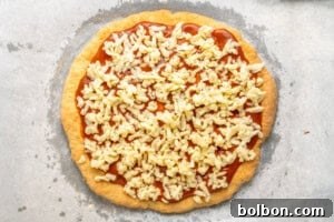 Freshly baked pizza with melted cheese and basil, ready to be sliced.
