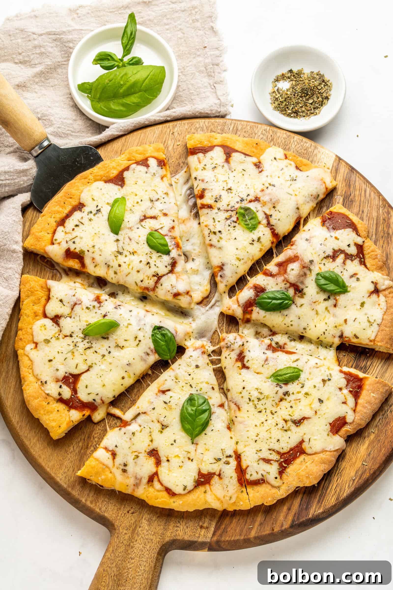 Close-up of cottage cheese pizza dough being rolled out on a lightly floured wooden surface, showing its smooth texture.