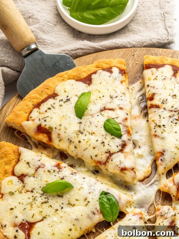 A freshly baked pizza with melted cheese, basil, and pepperoni on a golden cottage cheese crust.