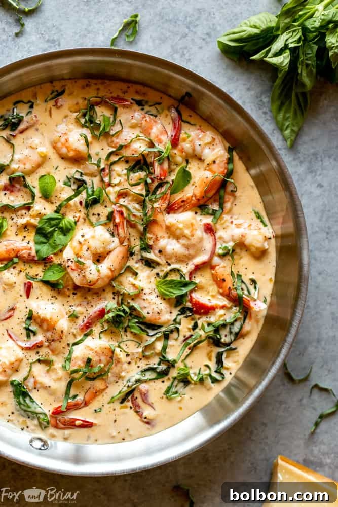 Creamy Parmesan Basil Shrimp served over pasta, showcasing the rich, creamy sauce and fresh basil garnish. Perfect easy dinner recipe.
