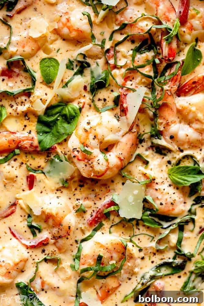 A serving of Creamy Parmesan Basil Shrimp ready to be enjoyed, highlighting the vibrant colors of basil and roasted red peppers.