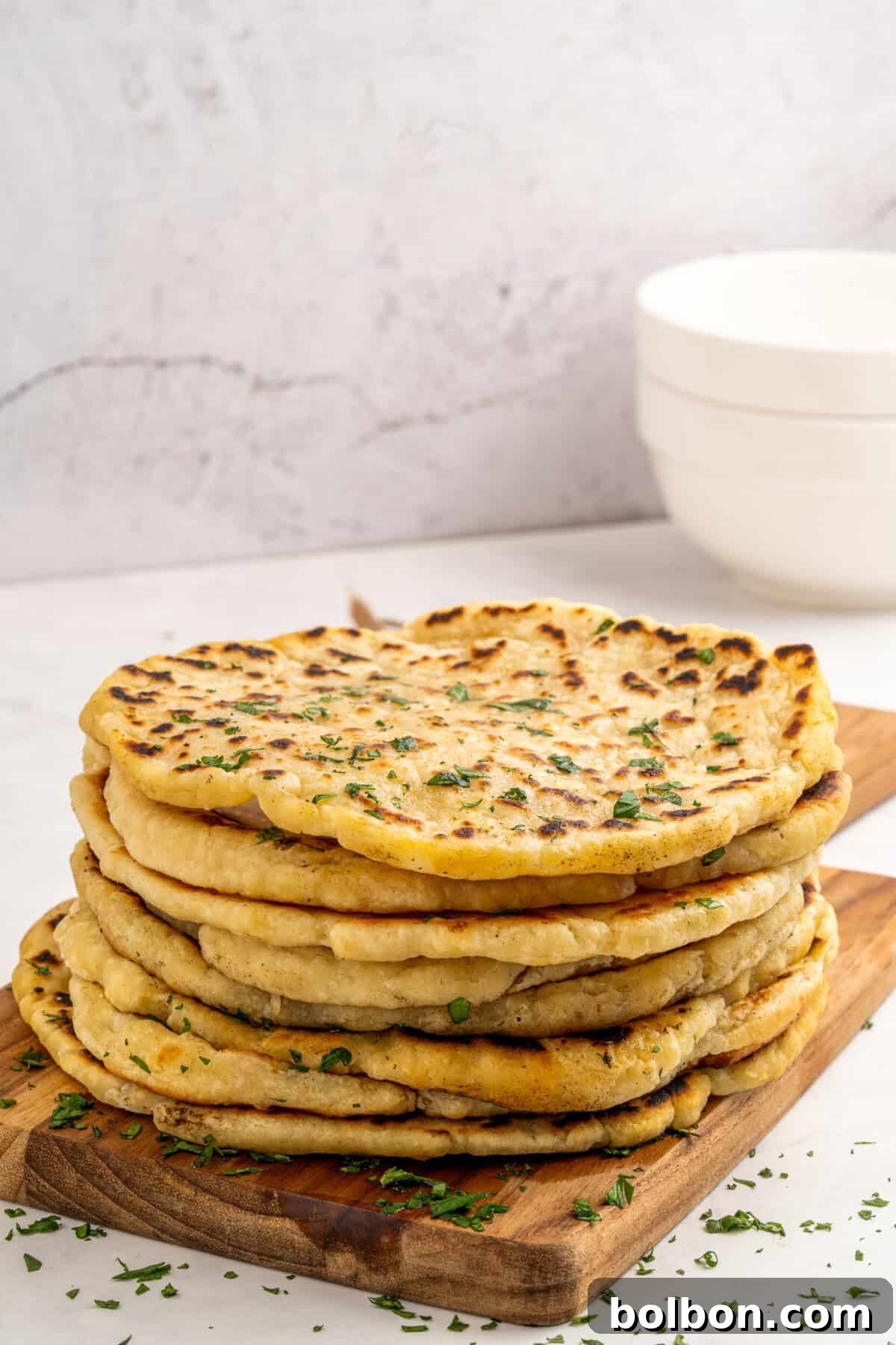 High-Protein Cottage Cheese Flatbreads 4 Freshly cooked cottage cheese pita bread, golden brown and puffed, served on a textured plate with a side of creamy dip.
