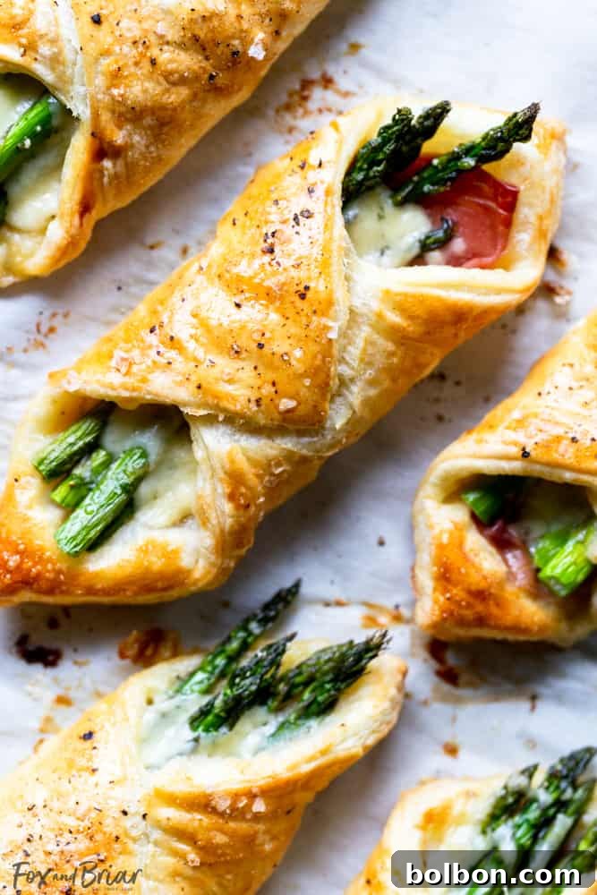Golden brown Prosciutto Asparagus Puff Pastry Bundles arranged elegantly on a serving platter, perfect for a spring brunch.