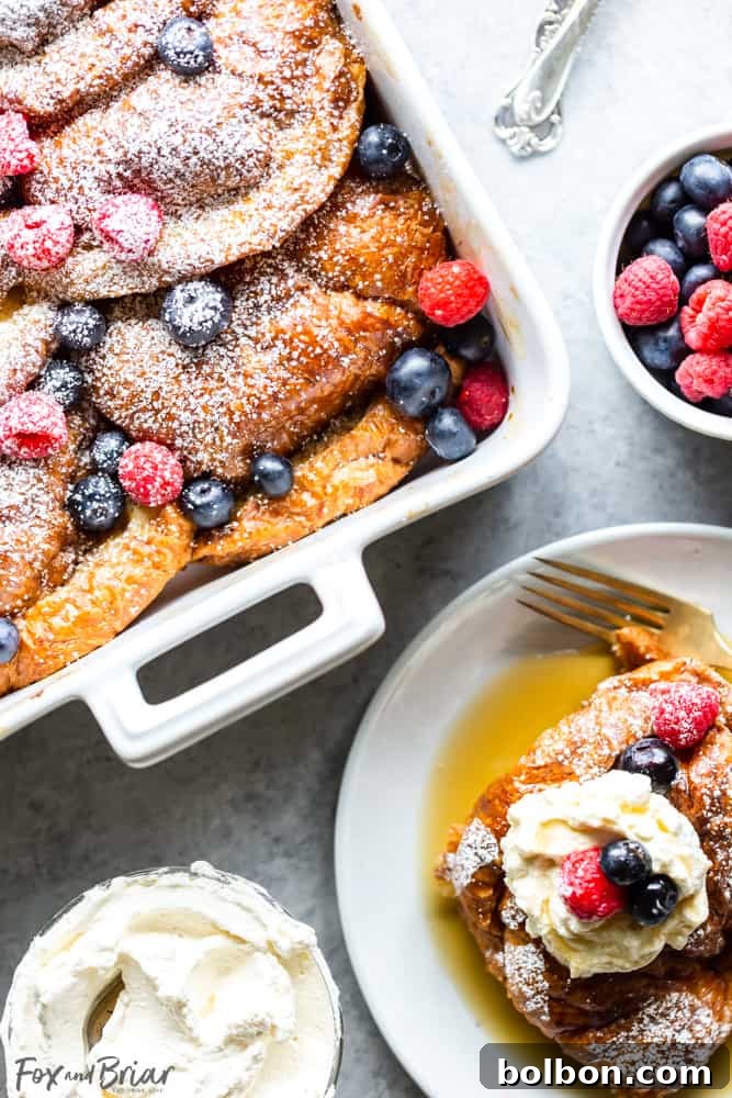 Overnight Croissant French Toast Strata 6 Croissant French Toast Casserole in pan with berries and next to a single serving of croissant french toast on a plate with whipped cream.