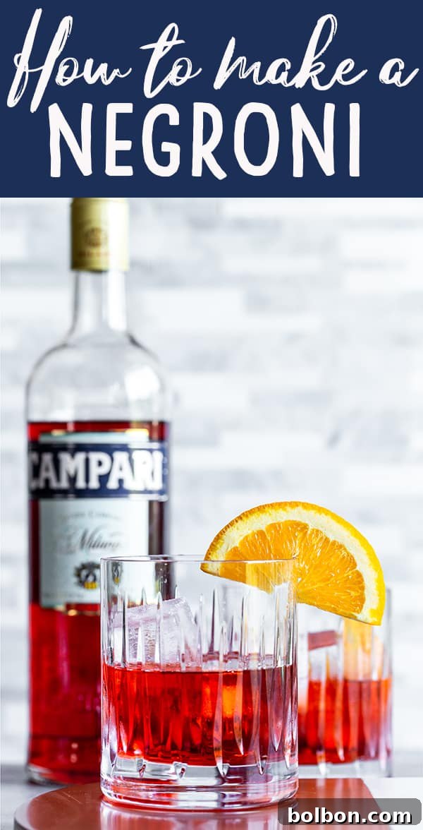 A glass of Negroni with an orange garnish next to a bottle of Campari and gin, showcasing ingredients.