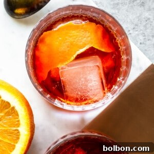 A prepared Negroni cocktail with ice and an orange peel garnish in a rocks glass.