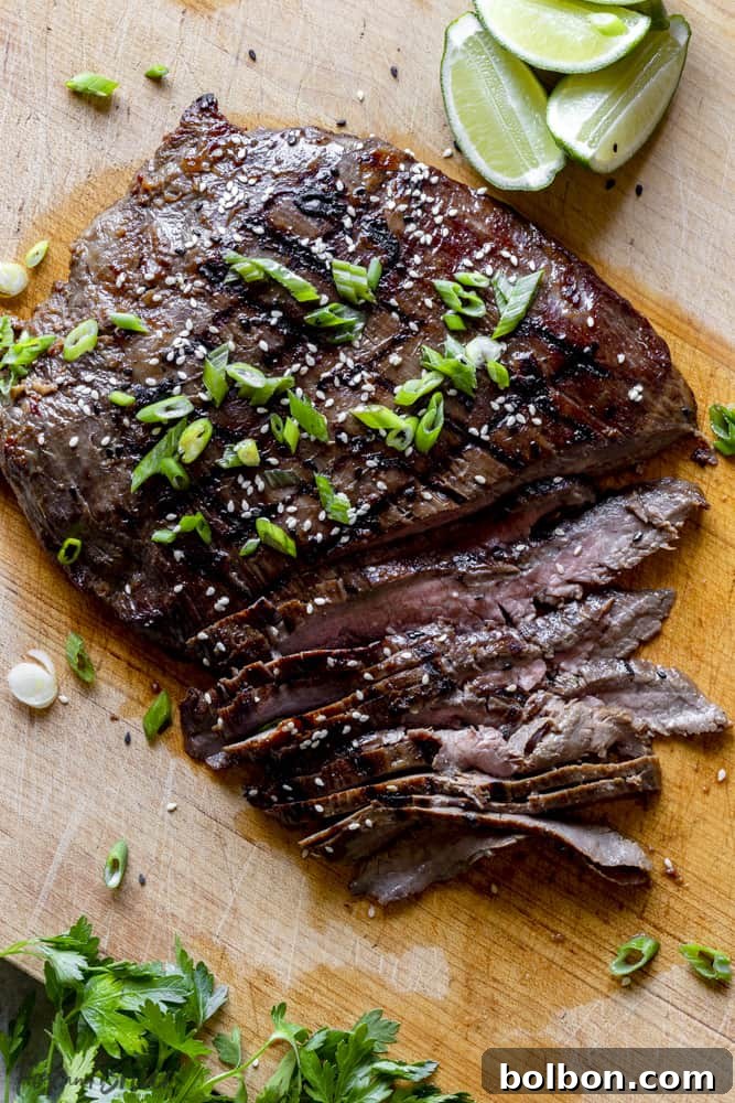Grilled flank steak on a cutting board, perfectly cooked and ready to slice.