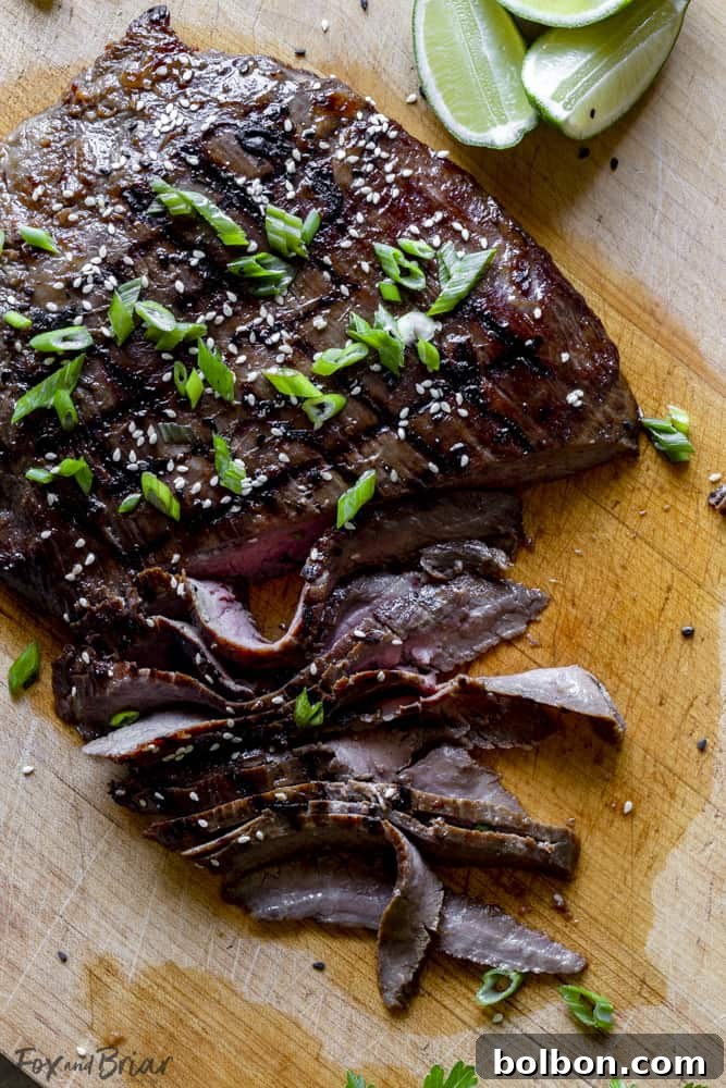 Close up view of perfectly sliced flank steak, demonstrating the 'against the grain' cutting technique.