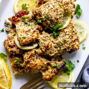 A top-down view of a serving of Oven Baked Greek Chicken Thighs, perfectly browned and garnished.