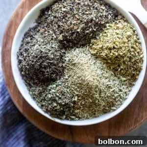 A small glass jar filled with homemade Italian seasoning, ready for storage.