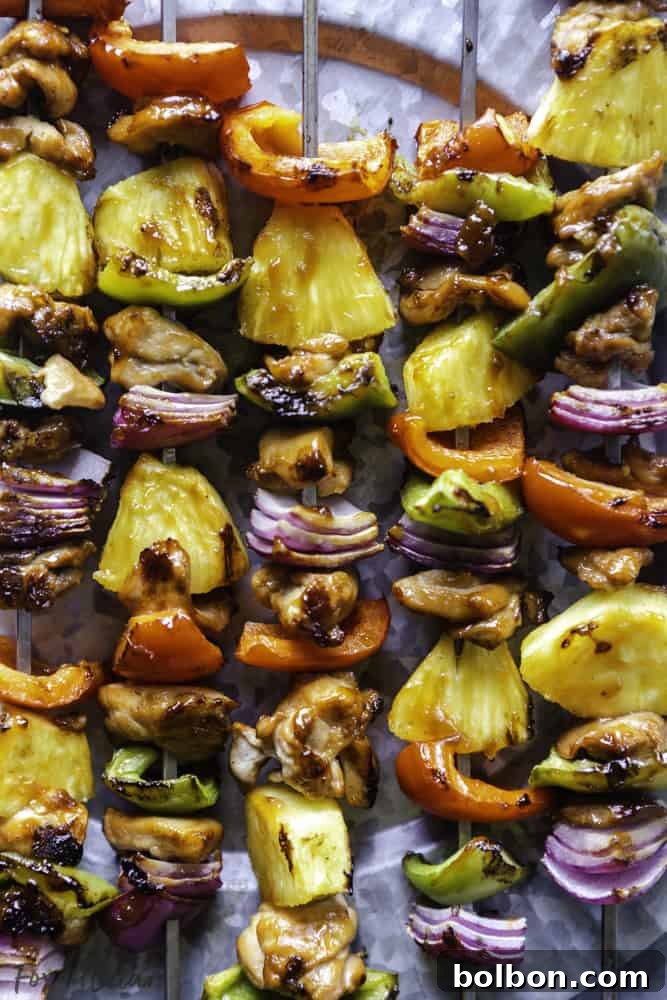 Vibrant Grilled Hawaiian Chicken Kabobs arranged on a platter, showcasing perfectly grilled chicken, golden pineapple chunks, and colorful bell peppers.
