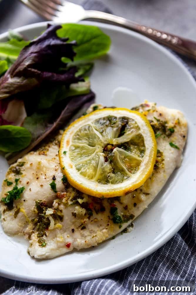 Full spread of lemon butter baked tilapia with roasted asparagus and turmeric rice on a dining table, ready to serve.