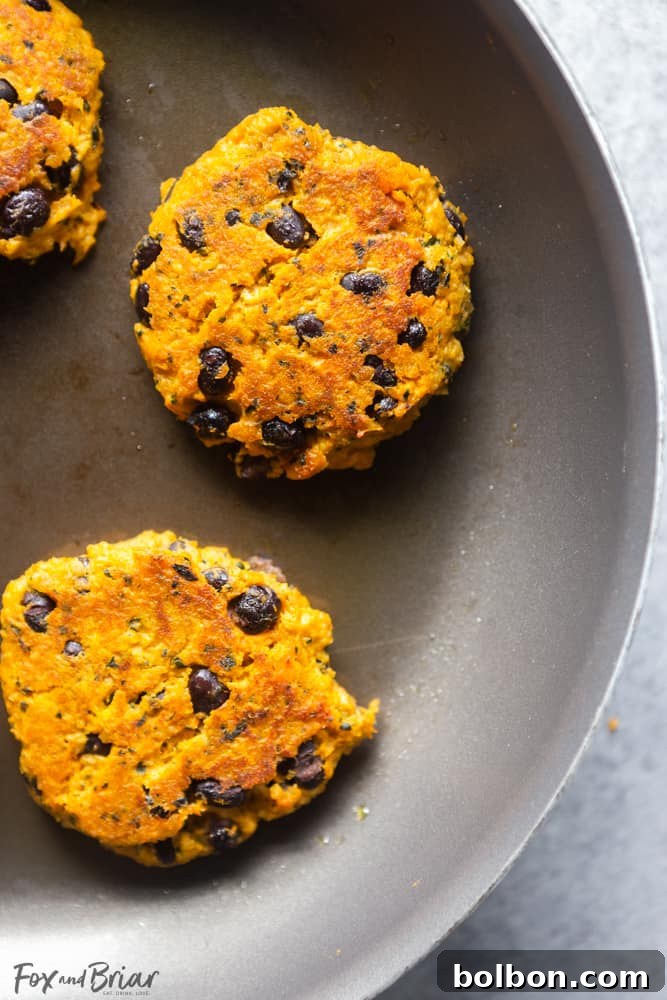 Sweet Potato Kale Black Bean Veggie Bites for Little Ones 4 A toddler's hand reaching for a Sweet Potato, Kale and Black Bean Patty