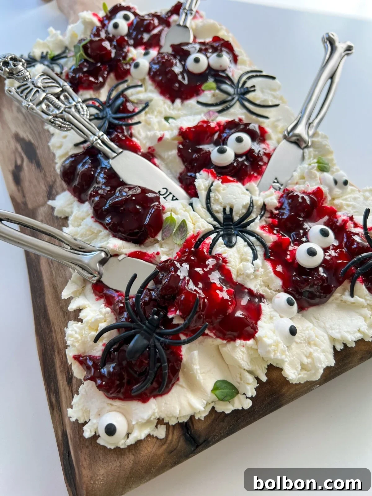 Ghastly Grazing Board 2 Goat cheese smeared on a cheese board with swirls of cherry jam