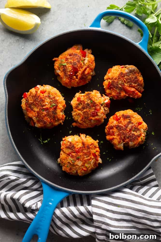 Quick Salmon Cakes 3 A vibrant close-up of several golden brown salmon patties sizzling in a hot skillet, showcasing their crispy exterior.