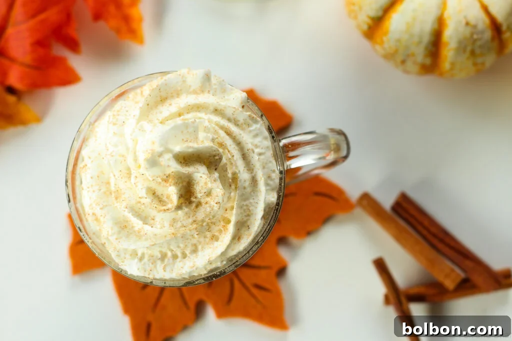 Homemade Autumn Spice Syrup in a glass bottle, surrounded by fall leaves, perfect for lattes and warm beverages