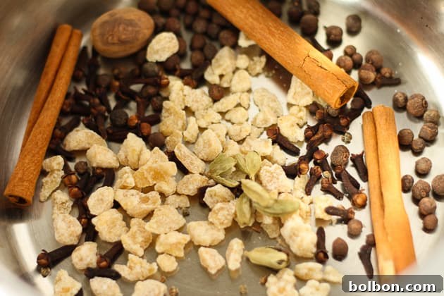 Mixture of water, sugar, and whole spices simmering in a pot on the stove, creating the fragrant autumn syrup