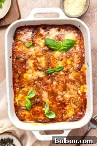 Classic Eggplant Parmesan (Parmigiana di Melanzane) Recipe 10 A baked eggplant parmesan casserole in a white dish, topped with melted cheese and fresh basil.