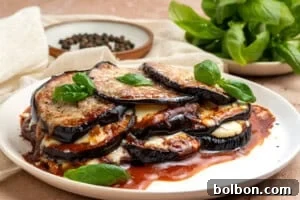 Classic Eggplant Parmesan (Parmigiana di Melanzane) Recipe 11 A plate of eggplant parmesan with layers of eggplant, tomato sauce, and melted cheese, garnished with fresh basil leaves.