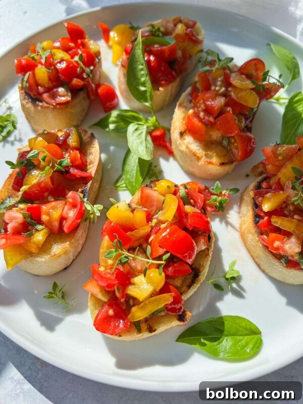 Fresh & Easy Mediterranean Bread Dipping Oil Recipe 5 A plate of Italian Bruschetta featuring toasted bread slices topped with diced red and yellow tomatoes, garnished with fresh basil leaves and microgreens, served on a white plate.