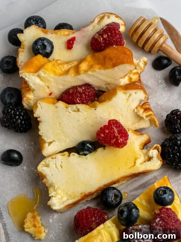 Slices of cheesecake topped with berries and honey.