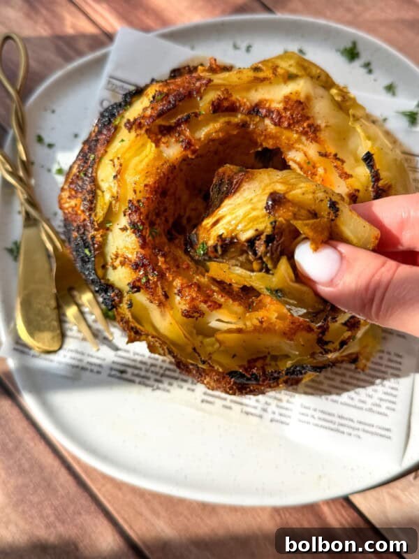 Viral No-Water Chicken Soup Recipe That Uses Just Broth 5 A crispy roasted slice pulled from a whole roasted cabbage served on a white plate.