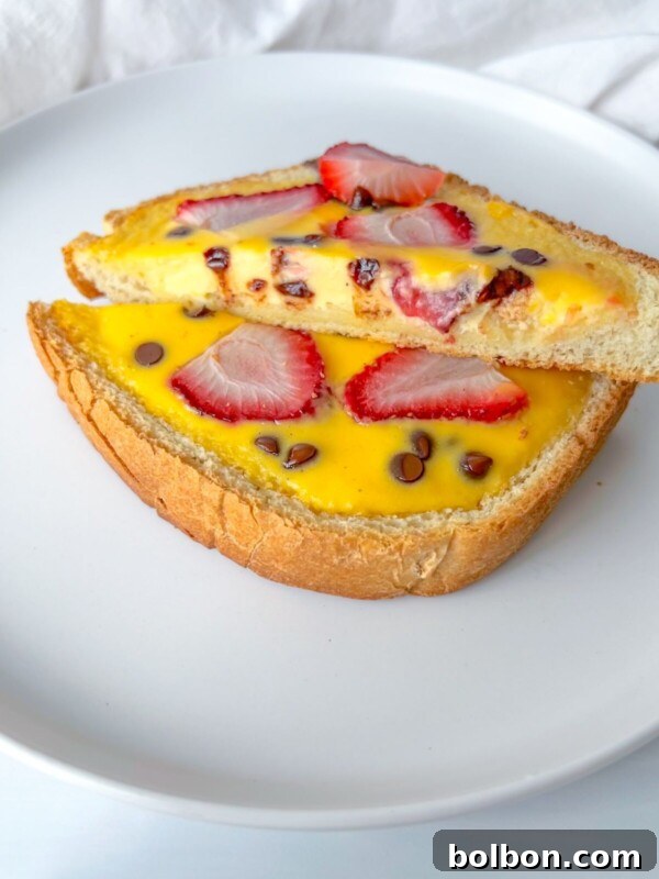 TikTok Viral Yogurt Noodles Recipe 7 Two slices of bread topped with yellow custard, fresh strawberry slices, and chocolate chips.
