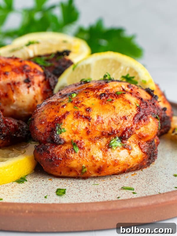 Grilled chicken thighs garnished with parsley and lemon