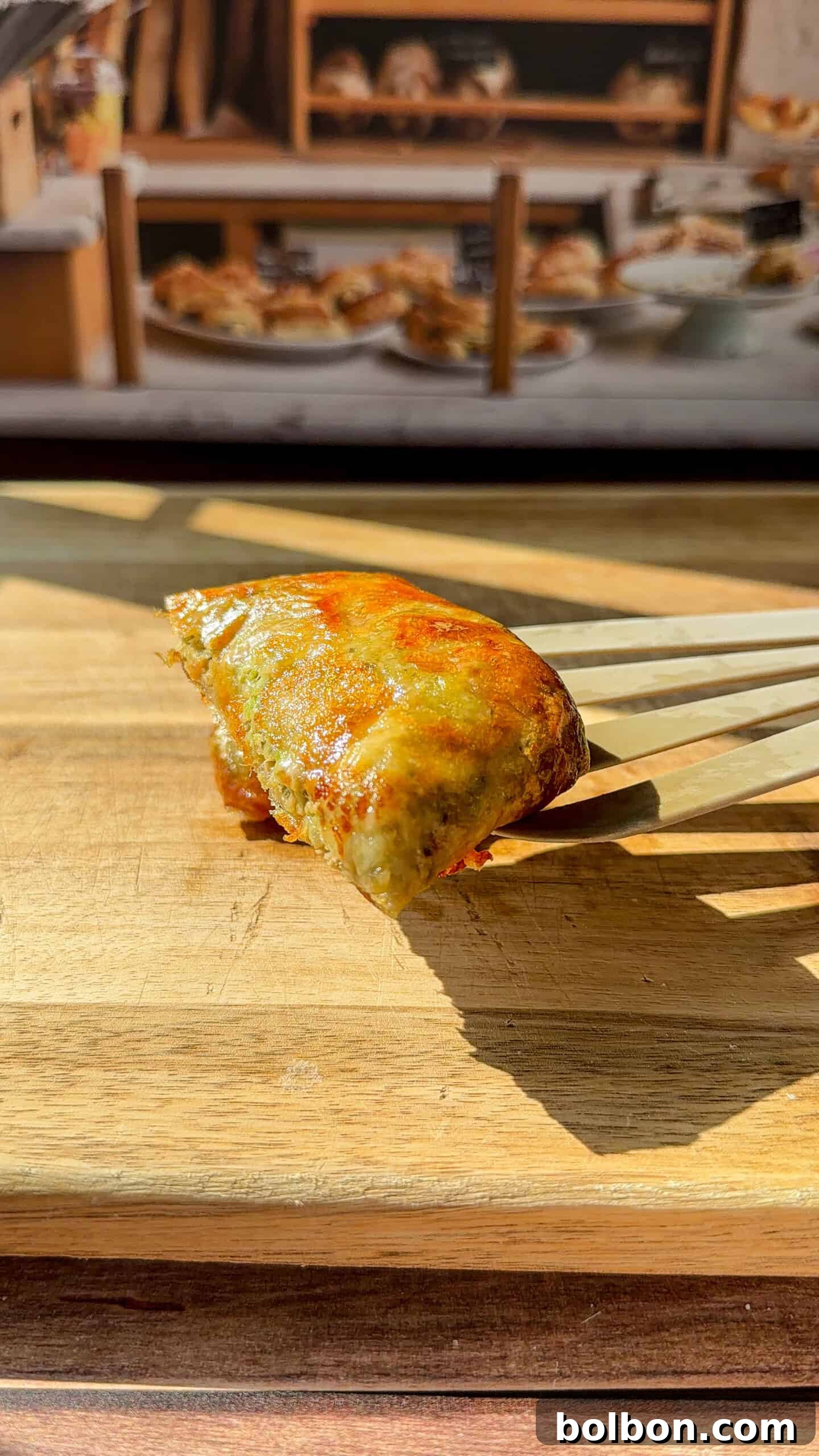 a person showing the inside of a crispy Rice Paper Tunacado melt