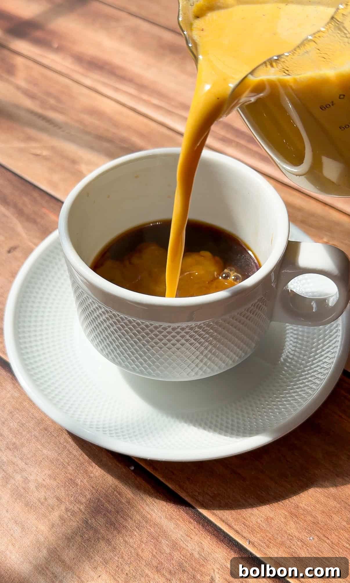 Homemade Pumpkin Creamer Recipe for Coffee 2 Golden turmeric latte being poured into white cup